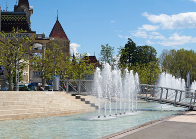 Aménagement de la place de la Navigation à Lausanne-Ouchy. Espace polyvalent avec bassins, jets d’eau modulables et création mobilier urbain.